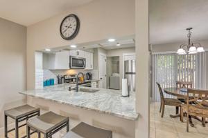 a kitchen and dining room with a clock on the wall at Fort Walton Beach Townhome Less Than 3 Mi to the Beach! in Fort Walton Beach