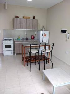 a kitchen with a table and chairs and a refrigerator at Costa Norte, iluminado y espacioso in Posadas