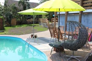 two chairs and an umbrella next to a swimming pool at Villa Bademeusel in Straupitz