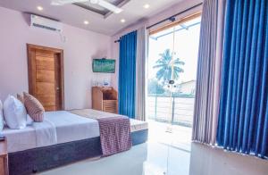 a bedroom with a bed and a large window at Villa 73 Unawatuna in Unawatuna