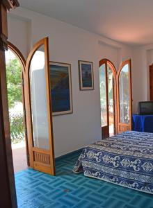 sypialnia z łóżkiem i lustrem w obiekcie Villa Luigina - seafront villa in Capo d'Orlando w mieście Capo dʼOrlando