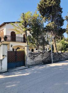 uma casa com um portão preto e uma cerca em Villa Luigina - seafront villa in Capo d'Orlando em Capo dʼOrlando