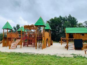 a playground with wooden play equipment in the sand at Apartmán U Sedmikrásky in Vaclavov u Bruntalu