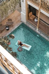 a woman is laying on a raft in a swimming pool at SHAN Villas Sukhumvit in Bangkok
