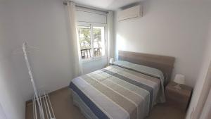 a small bedroom with a bed and a window at Apartamentos Dins Mar Apto. 10 in Torredembarra
