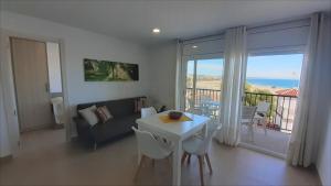 a living room with a couch and a table with chairs at Apartamentos Dins Mar Apto. 10 in Torredembarra +17 photos
