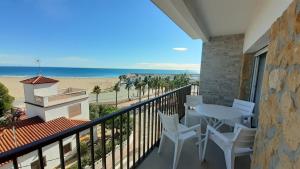 balcón con mesa y sillas y la playa en Apartamentos Dins Mar Apto. 10 en Torredembarra