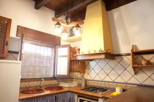 a kitchen with a sink and a stove top oven at Casa Huerta San Francisco in Casarabonela