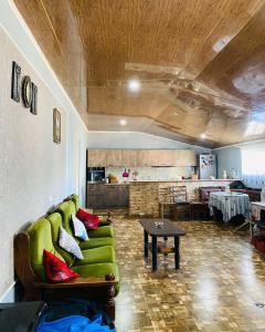 uma sala de estar com um sofá verde e uma mesa em Mamuka's Guesthouse em Udabno