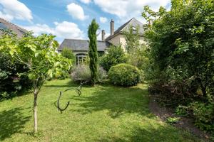 un jardín frente a una casa con un árbol en Ainsi de Suites - Chambres & table d'hôtes - Spa & massages en Reugny