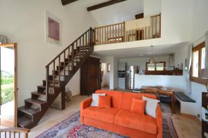 uma sala de estar com um sofá laranja e uma escada em Le Mas sous le Vent em Opio