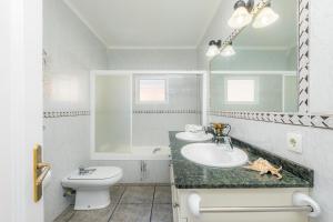 uma casa de banho com um lavatório, um WC e um espelho. em Costa den Blau em Porto Cristo