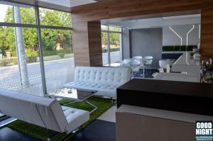 a living room with white chairs and a piano at Apartments Good Night in Niš