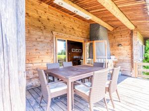 a wooden dining table and chairs on a deck at Traditional chalet with garden near Malmedy in Malmedy
