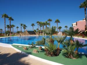 una gran piscina con palmeras en un complejo en Belvilla by OYO La Casa Az l, en Zahara de los Atunes