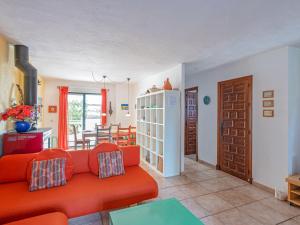 sala de estar con sofá rojo y comedor en Belvilla by OYO La Casa Az l, en Zahara de los Atunes