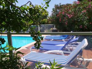 two blue and white lounge chairs next to a swimming pool at Beautiful holiday home with swimming pool in Monprimblanc