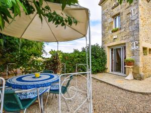 una mesa con sombrilla frente a un edificio en Beautiful holiday home with swimming pool, en Monprimblanc