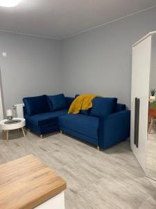 um sofá azul sentado numa sala de estar em Urocza i nowoczesna kawalerka - Łódź w pobliżu centrum em Lódź