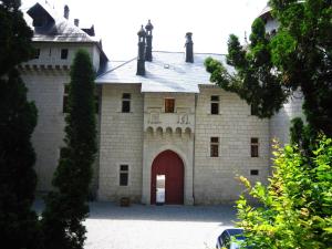een groot bakstenen gebouw met een rode deur bij Cosy castle with pool in Serri res en Chautagne in Serrières-en-Chautagne