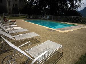 een groep stoelen en een zwembad bij Cosy castle with pool in Serri res en Chautagne in Serrières-en-Chautagne