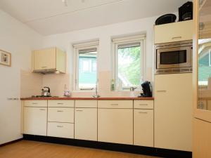 a kitchen with white cabinets and a sink at Villa with spacious garden near Heeten in Heeten