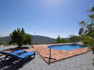 - une piscine avec 2 chaises longues à côté d'un complexe dans l'établissement Belvilla by OYO Villa Las Reinas, à Arenas