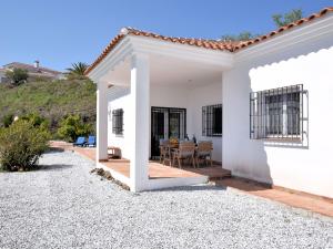 Cette maison blanche dispose d'une terrasse et d'une table. dans l'établissement Belvilla by OYO Villa Las Reinas, à Arenas