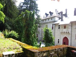 um grande castelo branco com uma porta vermelha em Castle with pool in Serri res en Chautagne em Serrières-en-Chautagne