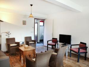 ein Wohnzimmer mit Stühlen, einem Tisch und einem TV in der Unterkunft Comfortable flat overlooking orchards in Eede
