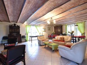 ein großes Wohnzimmer mit Sofas und einem Tisch in der Unterkunft Alluring Cottage in Englancourt with Fenced Garden in Englancourt