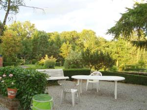duas cadeiras e uma mesa e dois bancos num jardim em Alluring Cottage in Englancourt with Fenced Garden em Englancourt