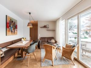 ヴェステンドルフにあるModern Apartment in Westendorf with Gardenのリビングルーム(テーブル、椅子、ソファ付)
