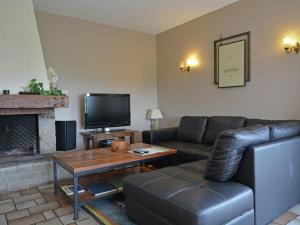 a living room with a couch and a table and a tv at Pretty villa with pool and jacuzzi in Carcassonne in Carcassonne