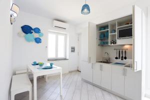 a kitchen with white cabinets and a white table at Casa Manì in Anacapri