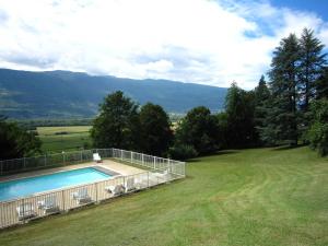 a swimming pool in the middle of a grass field at Cosy castle with swimming pool in Serrières-en-Chautagne