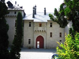 Serrières-en-ChautagneにあるCosy castle with swimming poolの赤い扉付きの大きなレンガ造りの建物