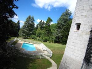 Serrières-en-ChautagneにあるCosy castle with swimming poolの塔の隣の庭にあるスイミングプール