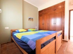 ein Schlafzimmer mit einem großen Bett mit blauer und gelber Bettwäsche in der Unterkunft Belvilla by OYO Villa Bandoleros in Arenas