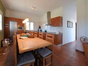 a kitchen with a wooden table and a dining room at Belvilla by OYO Villa Bandoleros in Arenas