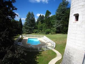 a swimming pool in a yard next to a tower at Cosy chateau with pool in Serrières-en-Chautagne