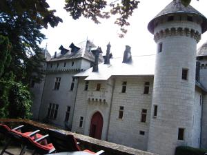 a castle with a tower and chairs in front of it at Cosy chateau with pool in Serrières-en-Chautagne