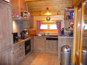 a small kitchen with wooden cabinets and a sink at Sunny Chalet in Les Gets with Jacuzzi in Les Gets
