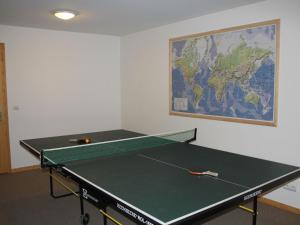 a ping pong table in a room with a map on the wall at Sunny Chalet in Les Gets with Jacuzzi in Les Gets