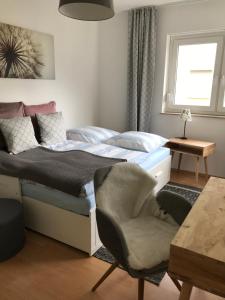ein Schlafzimmer mit einem Bett, einem Stuhl und einem Fenster in der Unterkunft Ferienapartment Alma in Erfurt