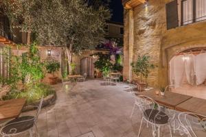a patio with tables and chairs and plants at Corte Alma Spa and Luxury Home in Gargnano