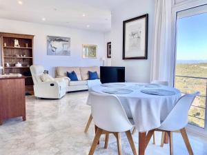 - un salon avec une table, des chaises et un canapé dans l'établissement Impresionantes Vistas Mar en el centro de Begur, à Begur