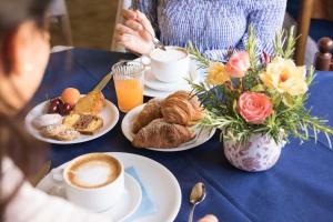 una mesa con platos de comida y tazas de café en Hotel Gialpina en Rímini