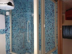 a bathroom with a shower with blue tiles at Casa Vacanze Samira in Fondachello