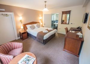 a hotel room with a bed and a desk at The Frocester in Stonehouse